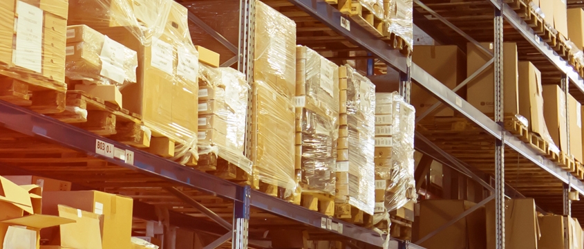 Huge distribution warehouse with high shelves and forklift